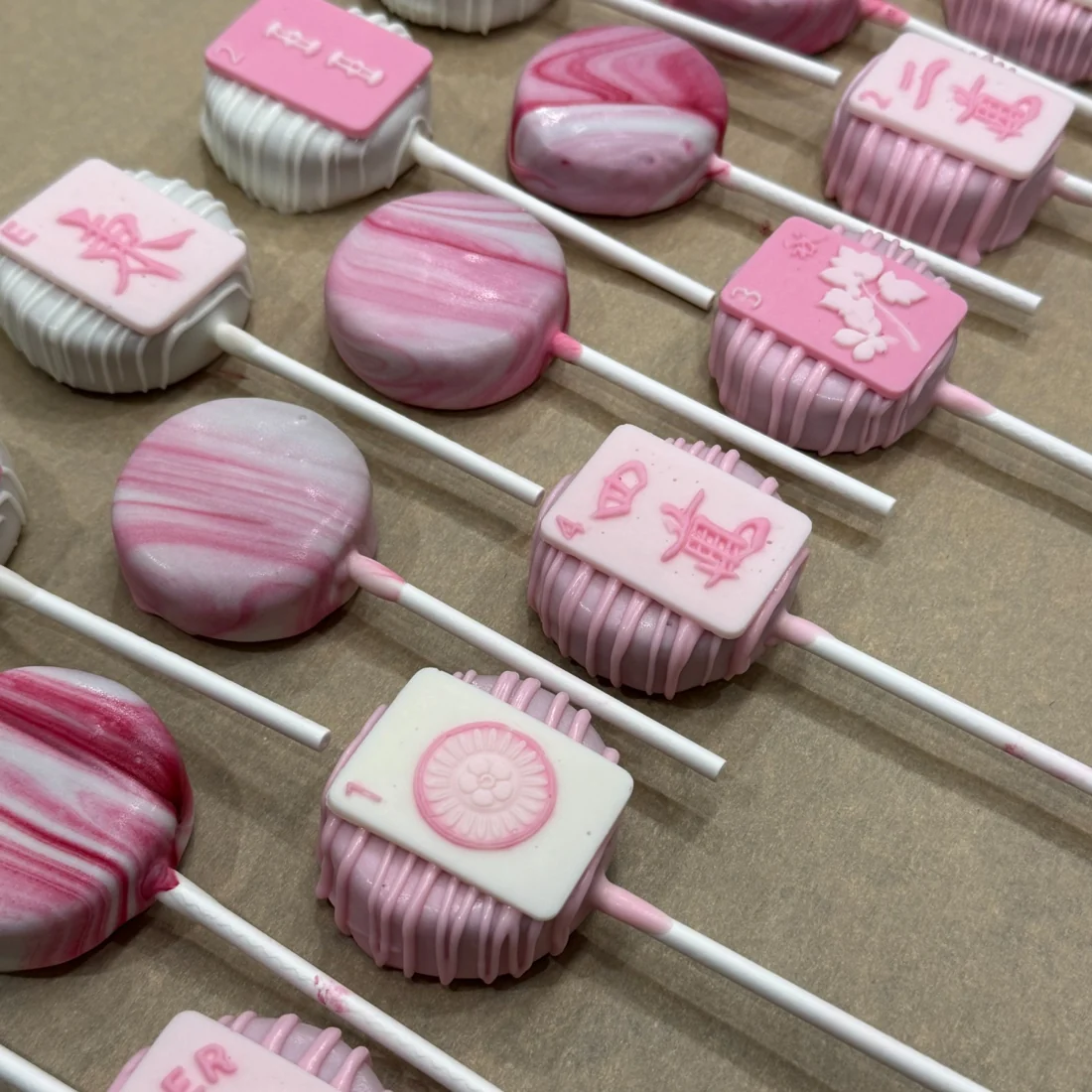 Pink mahjong-themed custom cake pops with hand-decorated tiles